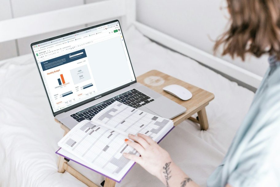 gestion administrative Person utilisant un ordinateur portable sur un bureau, feuilletant un carnet.