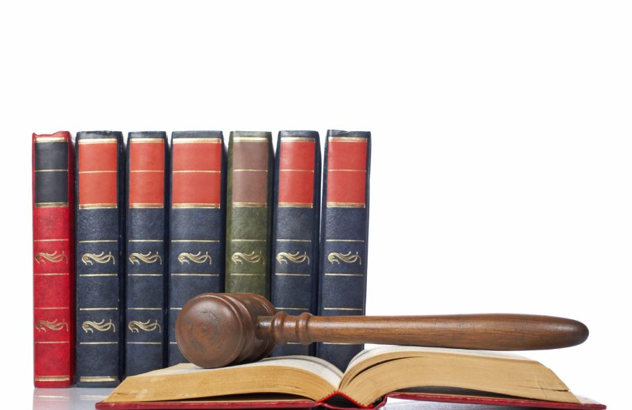 conseil social Une mallette en bois sur un livre, avec une bibliothèque de livres juridiques en arrière-plan.