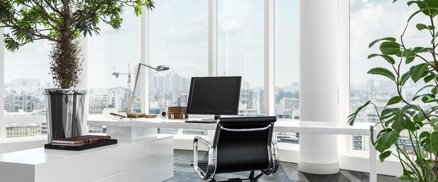 Le Carrefour Numérique Bureau moderne avec un ordinateur, des plantes et une vue sur la ville.